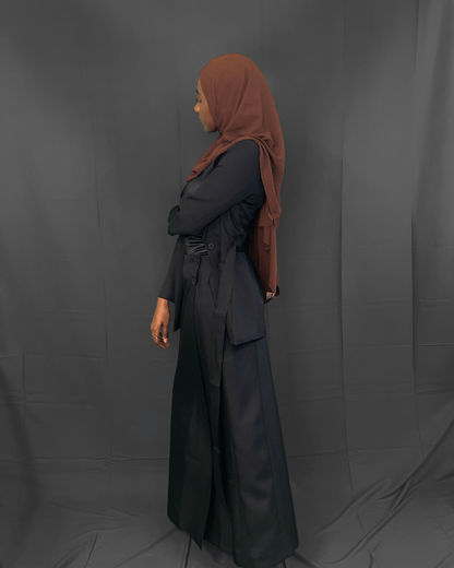 women wearing a black belted suit blazer paired with a side wrap maxi skirt suit also in black